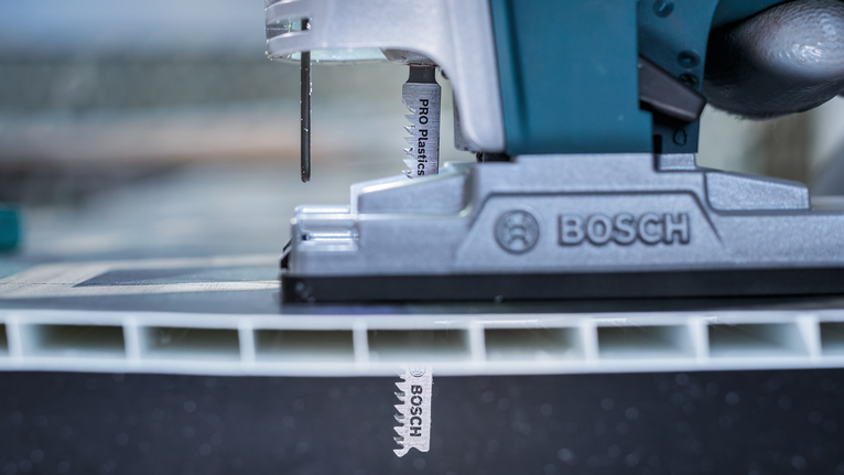 拼图锯切割一片塑料材料。