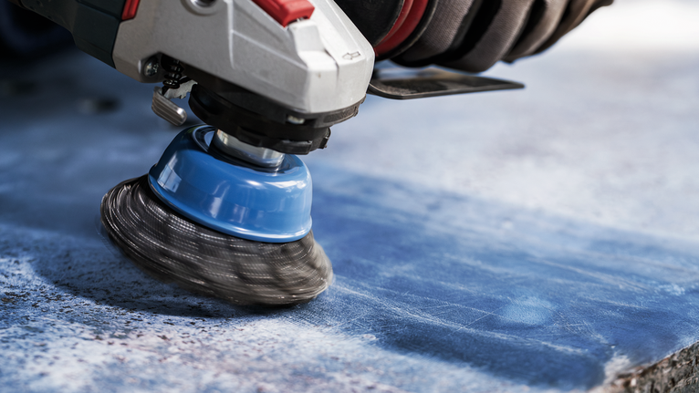 佩戴安全设备的人员使用旋转刷清洁石材表面。