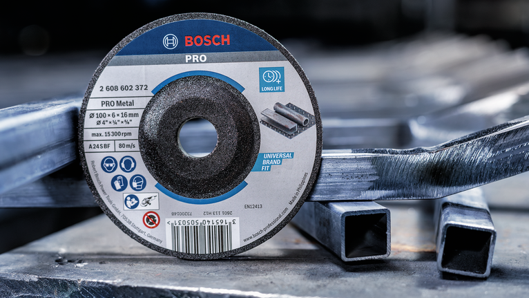 切割盘放置在工业环境中堆叠的金属管上。