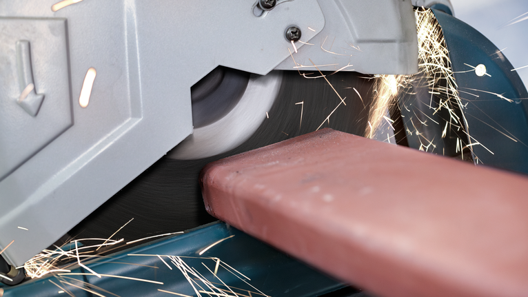 切割锯切割金属梁，产生火花。