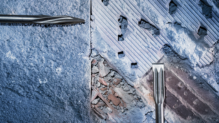 两个凿子钻头从墙面去除混凝土。