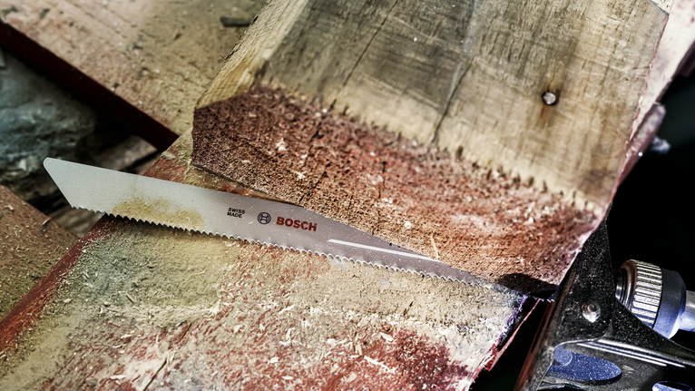 车间里，锯片正在切割一根厚木梁。