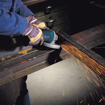 佩戴安全设备的人研磨金属梁，产生火花。.