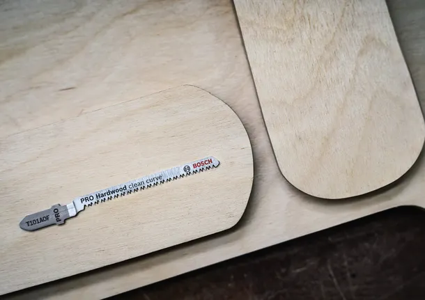 拼图锯刀片放在边缘圆润的木板上。