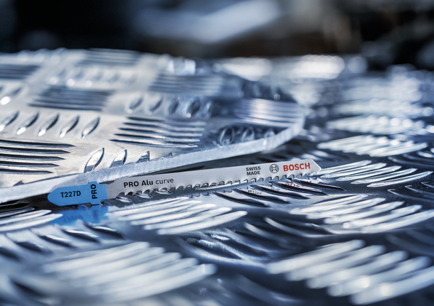 金属拼图锯片放在纹理铝板上。