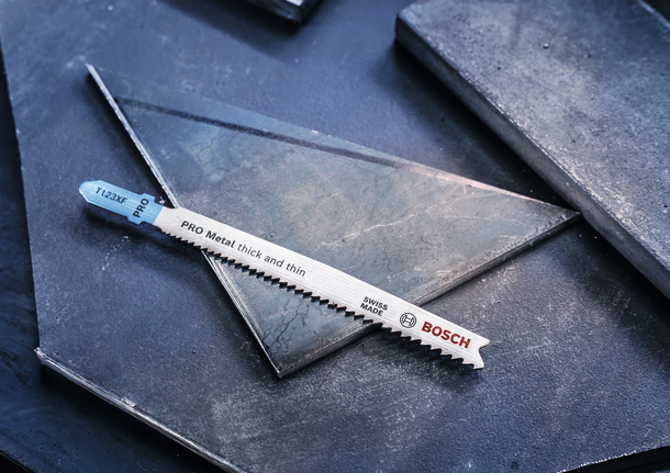 金属拼图刀片放在深色金属板上。