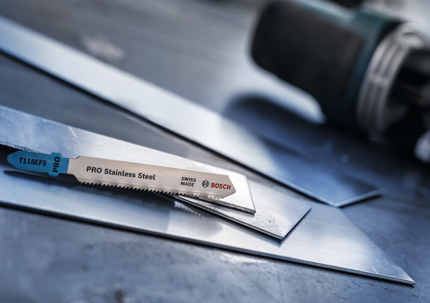 车间内，拼图锯刀片放置在不锈钢板上。