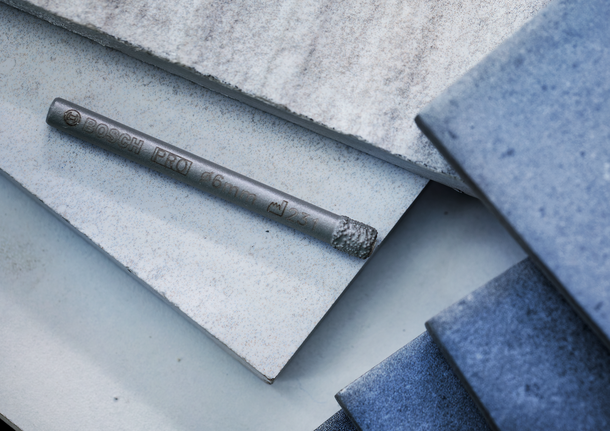 钻头放在堆叠的瓷砖上。