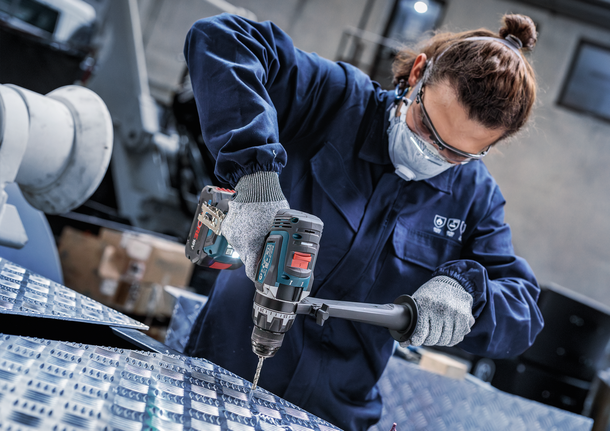 佩戴安全设备的人员钻入金属表面。