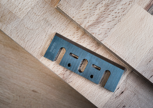 金属多用途刀片放置在堆叠的木板上。