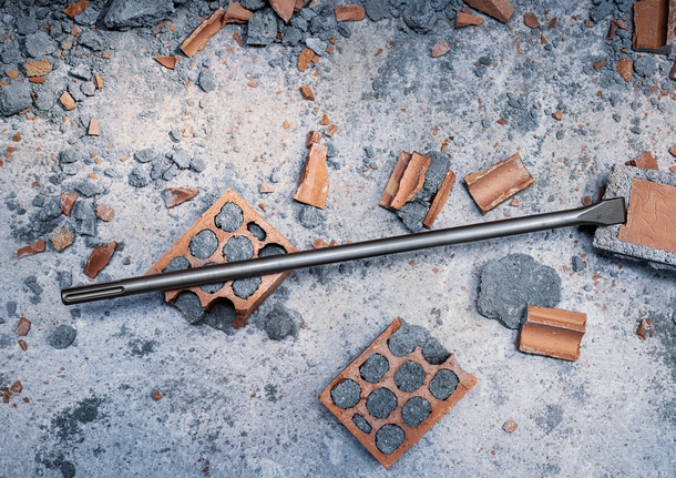 建筑工地上的凿子被碎砖和混凝土碎片包围。