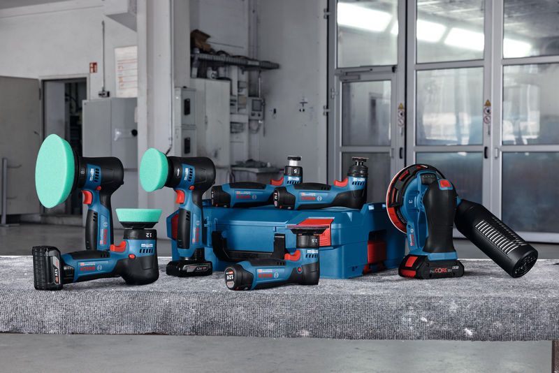 车间工作台上配有蓝色储物盒的无绳抛光和打磨工具。.