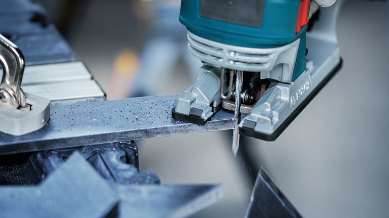 车间里，拼图锯正在切割金属棒。