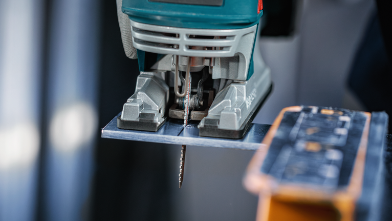 拼图锯在工作台上切割金属板。