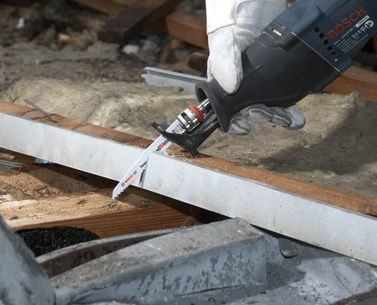 佩戴安全设备的人员使用往复锯切割木梁。.