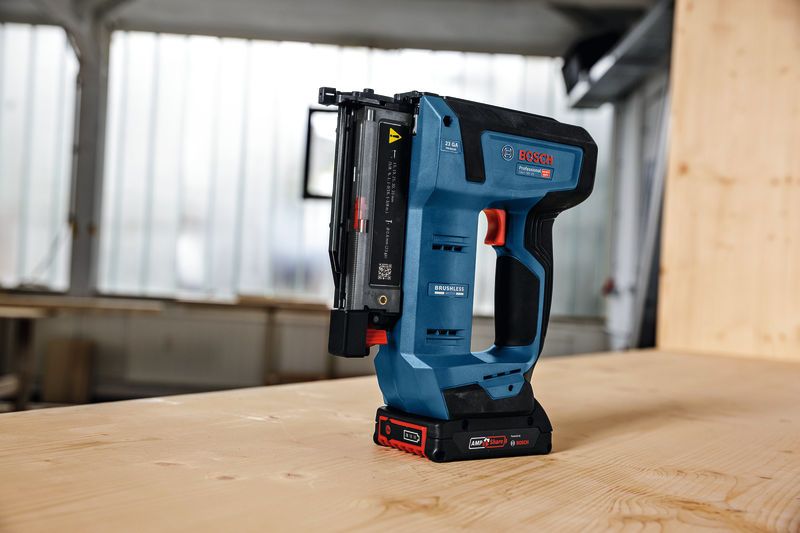 无绳钉枪直立在车间的木桌上。.