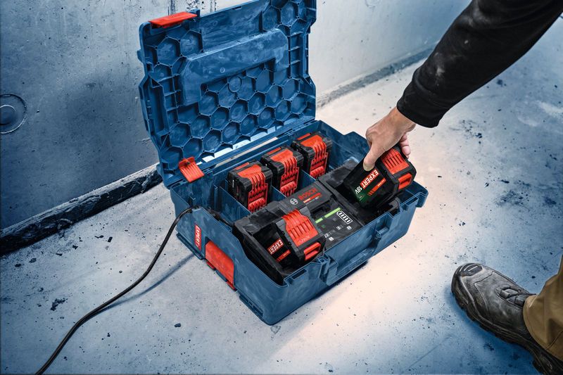 一名工人将电池放入车间的便携式充电站。.