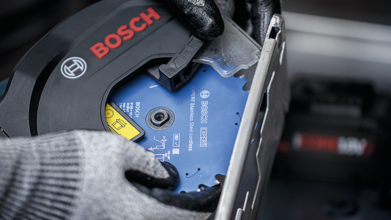 佩戴安全设备的人员安装圆锯片。.