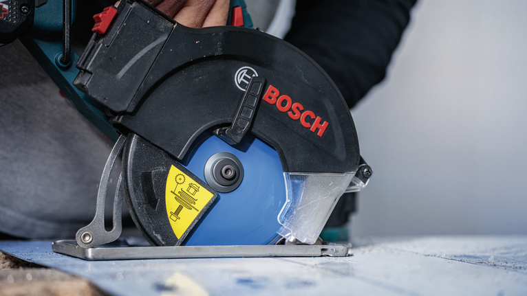 佩戴安全设备的人员使用圆锯切割木材。.