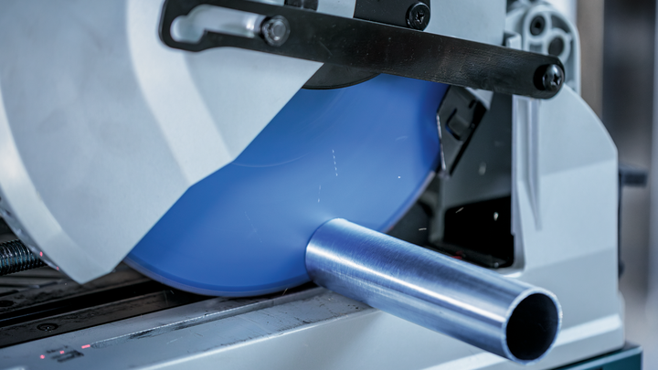 在近距离工业环境中，圆锯正在切割金属管道。.