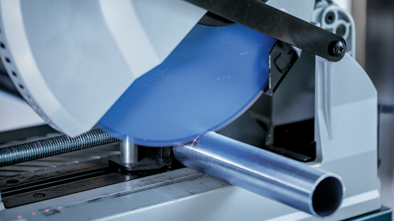 金属切割锯切割圆形金属管，发出火花。.