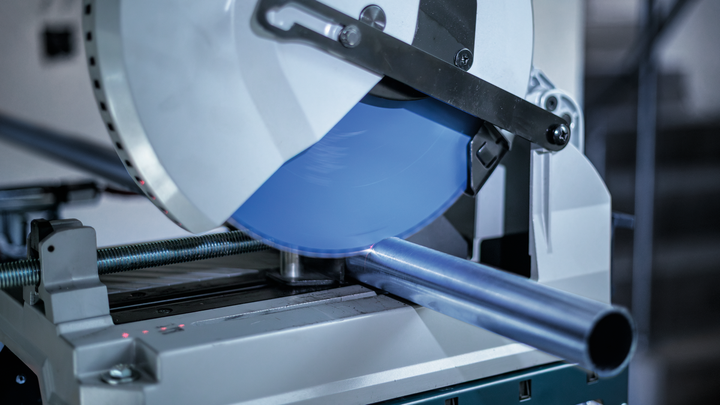 金属切割锯在车间切割钢管。.