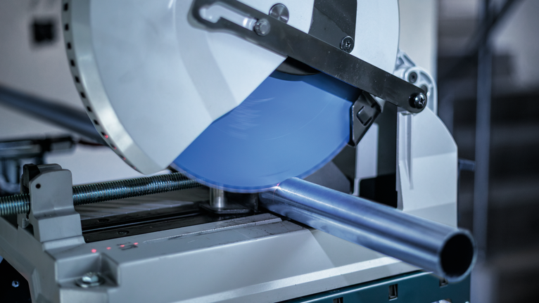 金属切割锯在车间切割钢管。.