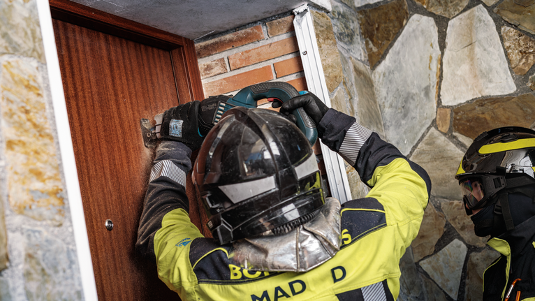 佩戴安全设备的人员操作电动工具切开木门。.