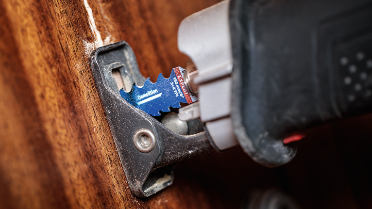 带有拆除刀片的振荡多功能工具可切割木材。.