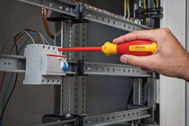 使用绝缘螺丝刀调整配电盘内线路的人员。