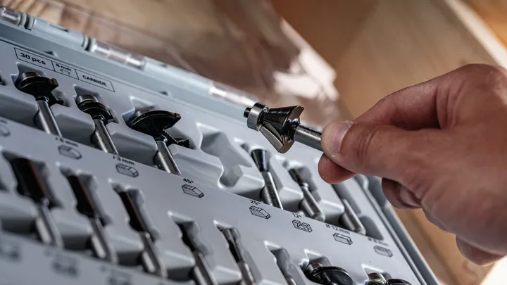 人们从有组织的工具包中选择一个路由器钻头。.