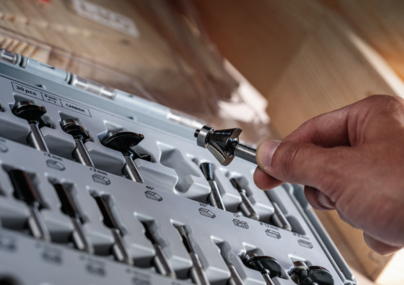 人们在车间环境中从一组有序的钻头中选择一个钻头。.