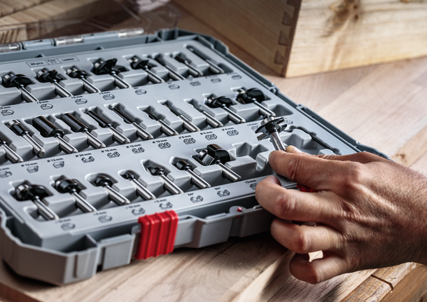 人们在木制工作台上从整齐排列的钻头中挑选钻头。.