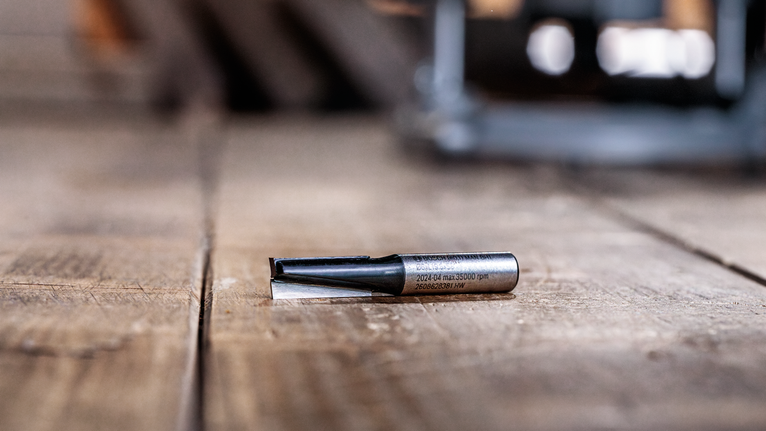 路由器钻头放置在车间的木质表面上。.