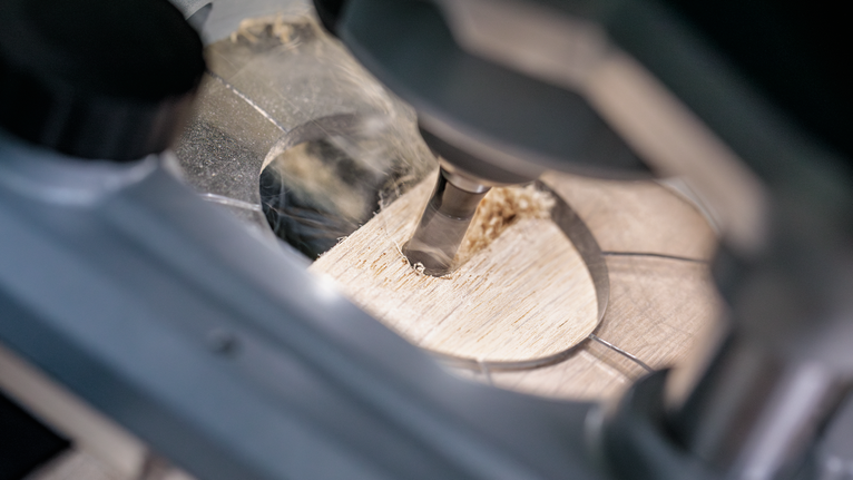 钻头在木板上进行精确的圆形切割。.