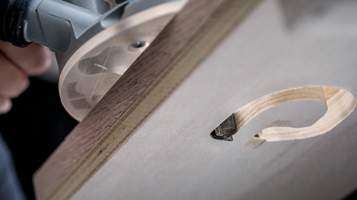 木工铣刀在木板上雕刻出精确的圆孔。.