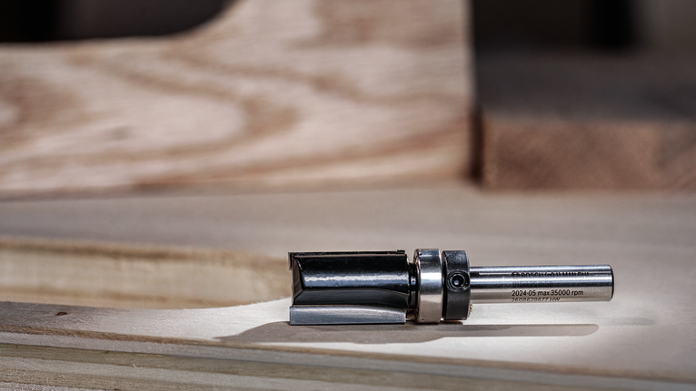 金属路由器钻头放置在木质工作表面上。.