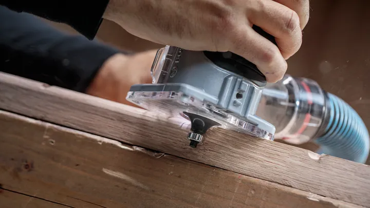 人们使用手持式路由器来塑造木板的边缘。.