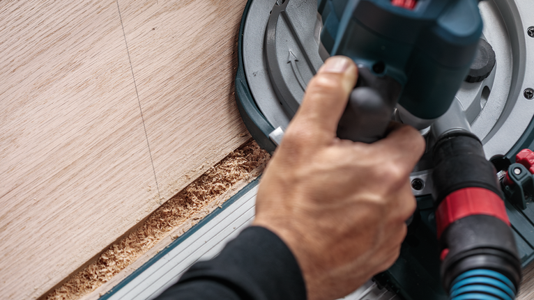 人们操作圆锯沿直线切割木材。.