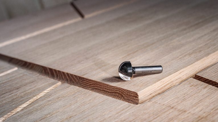 硬质合金铣刀放在带有新切槽的层压木板上。.