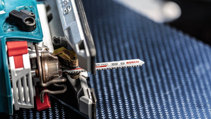 带有金属刀片的拼图，放置在带纹理的蓝色表面上。.