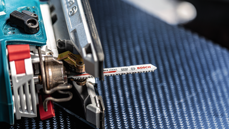 带有金属刀片的拼图，放置在带纹理的蓝色表面上。.