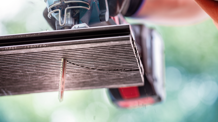 一名佩戴安全设备的人员使用电锯切割瓷砖。.