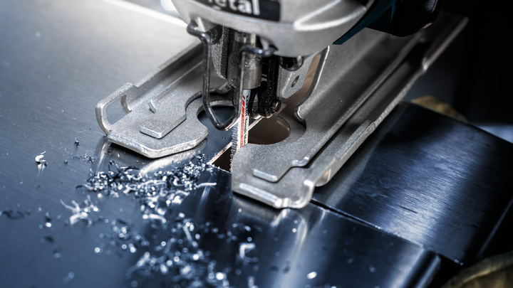 拼图在闪亮的金属板上切割出一个精确的孔。.