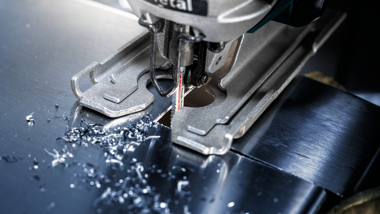 拼图在闪亮的金属板上切割出一个精确的孔。.