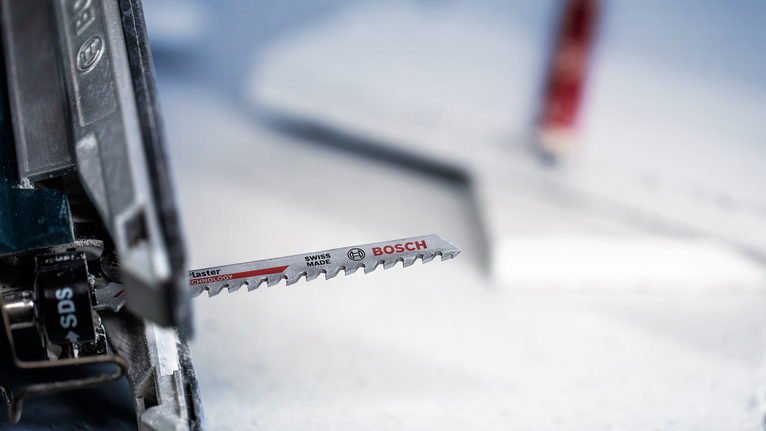 安装在电动工具上的拼图锯刀片，准备进行切割。.