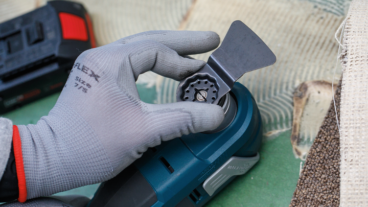 佩戴安全设备的人员将刀片安装到电动工具上。