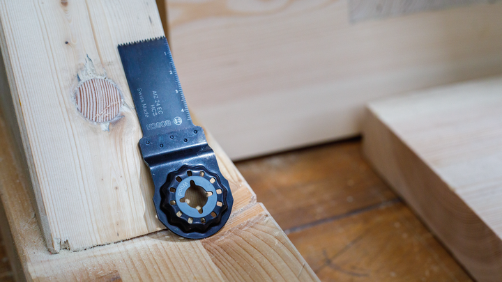 振荡锯片位于带有圆形切口的木梁上。