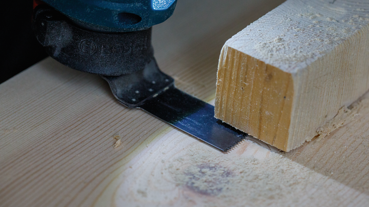 振荡多功能工具切割一块木头。