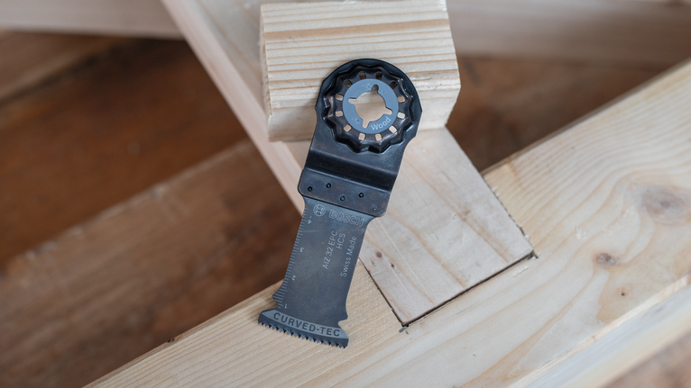 振荡锯片放置在堆叠的木梁上。